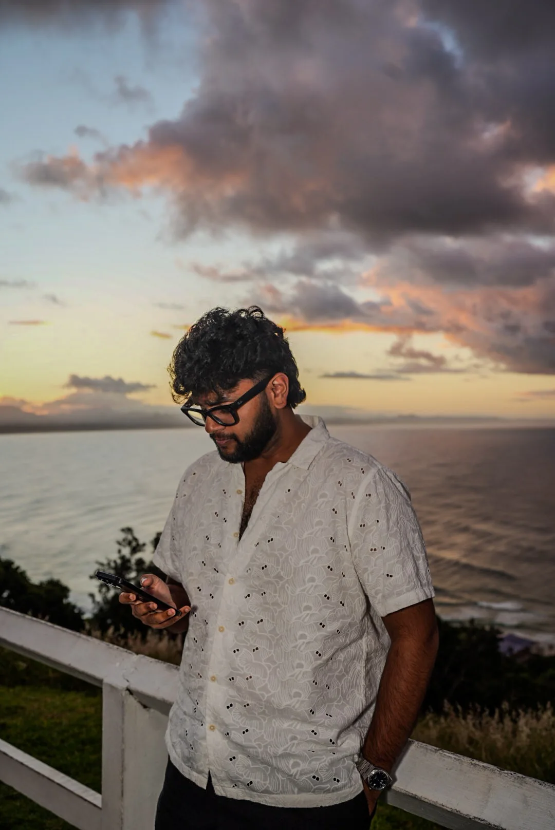 Jeevan, founder of ThatFilmographer, looking at his phone at sunset